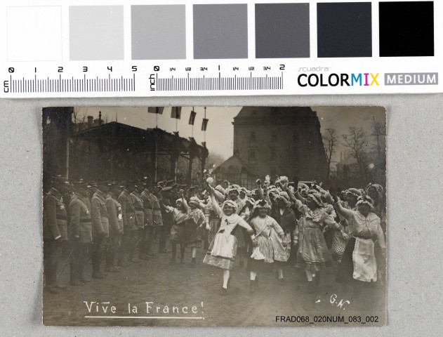 Défilé de petites Alsaciennes en costume traditionnel devant des militaires français.
