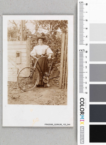 Jeune femme tenant une bicyclette.